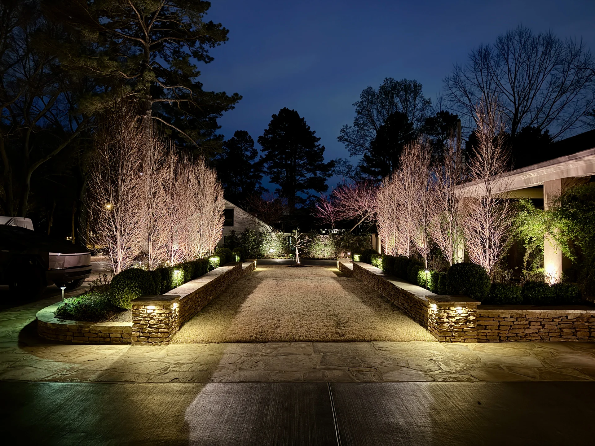 Green Earth’s premium Memphis yard featuring layered LED uplighting on trees and warm pathway lights for safety and ambiance.
