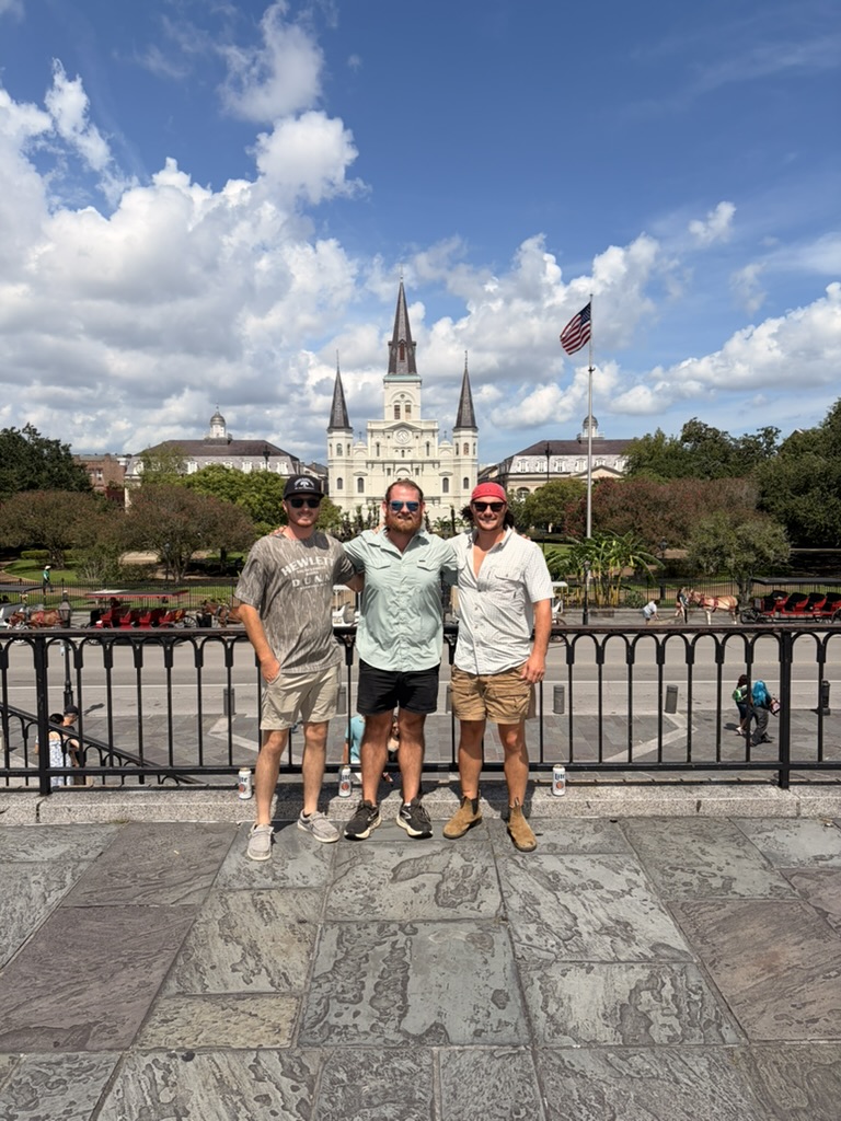 Green Earth team on a trip posing in front of a cathedral and fountain