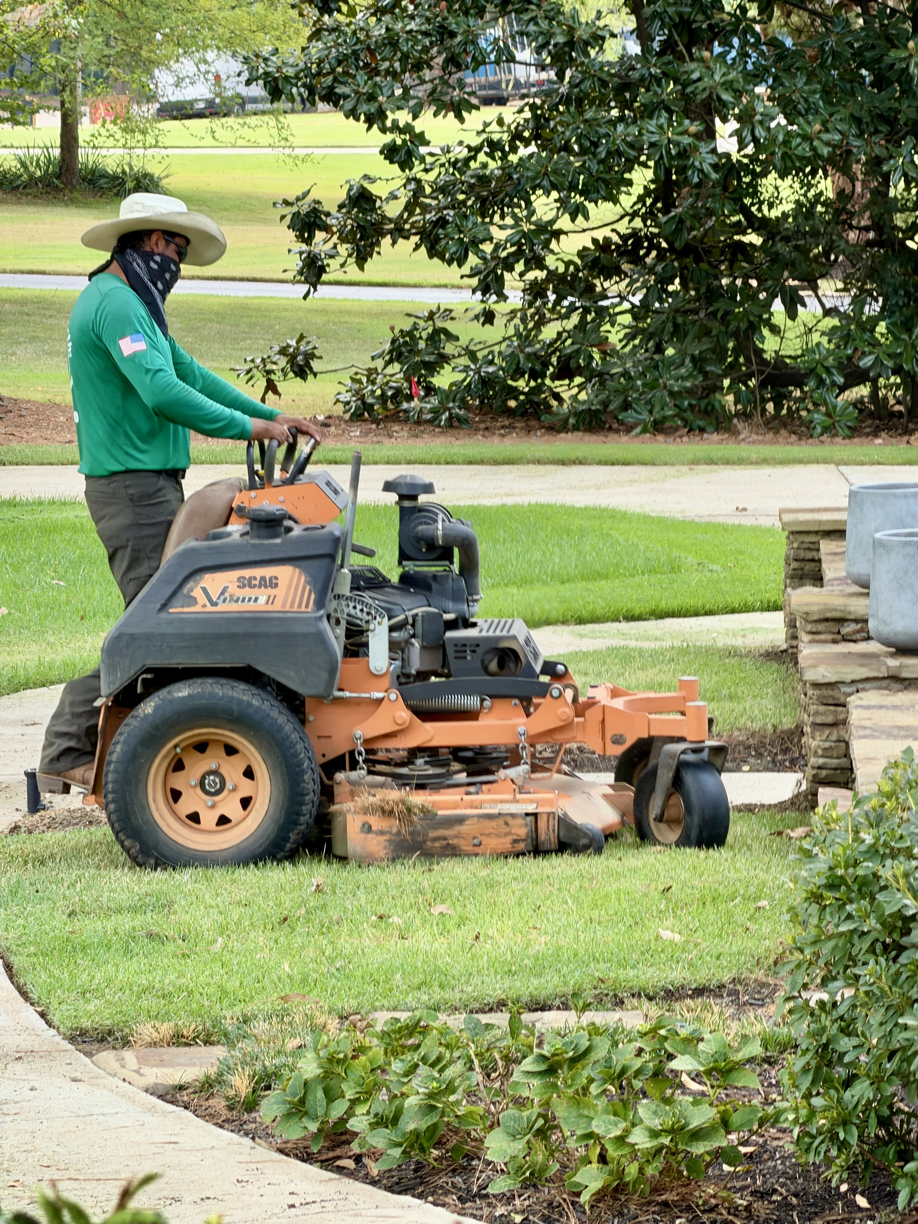 Green Earth crew member operating a Scag zero-turn mower